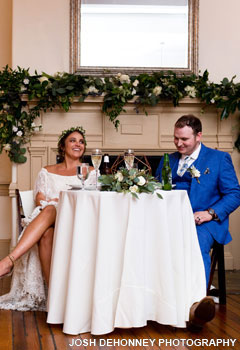 Bride and groom sitting at a sweetheart table at their wedding at the Historic Yellow Springs